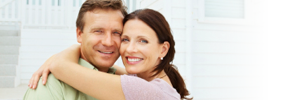 Man and woman happily embracing in front of a home. Man and woman happily embracing in front of a home.